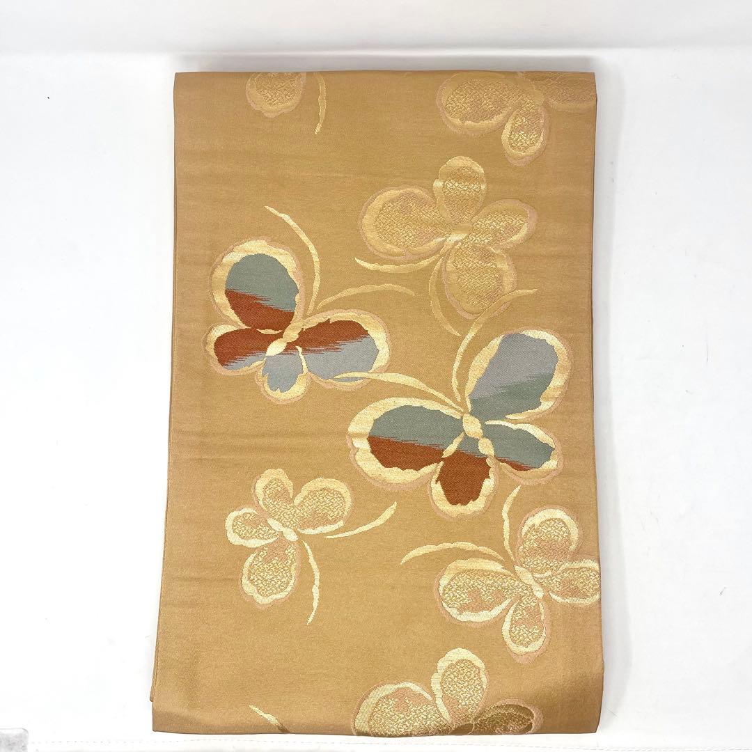 ［ 名古屋帯/ポリエステル ］化繊　柔らかい橙系の色　蝶　洗濯　洗える