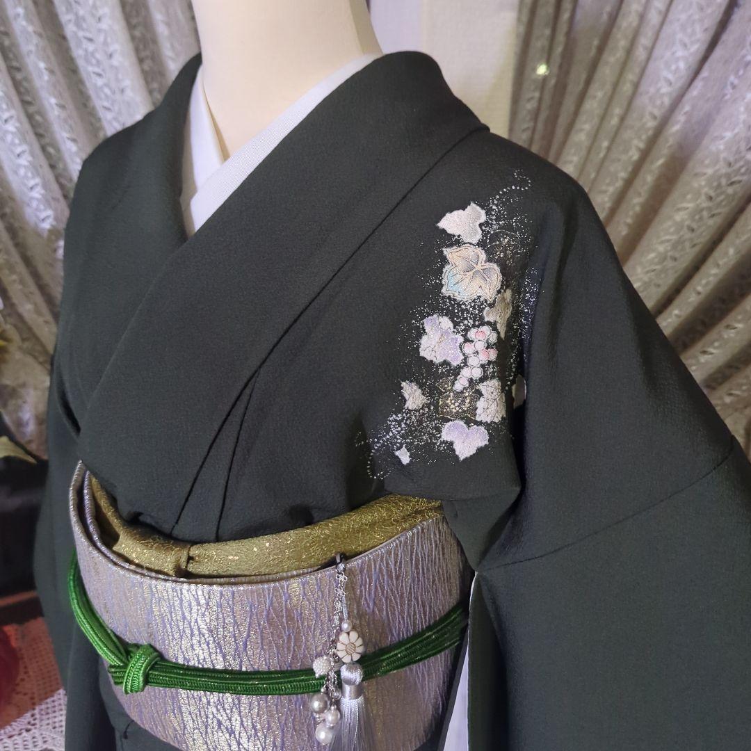 落款が入ります、青丹色の地に煌めく葡萄柄が繊細な美しさを見せる正絹訪問着です