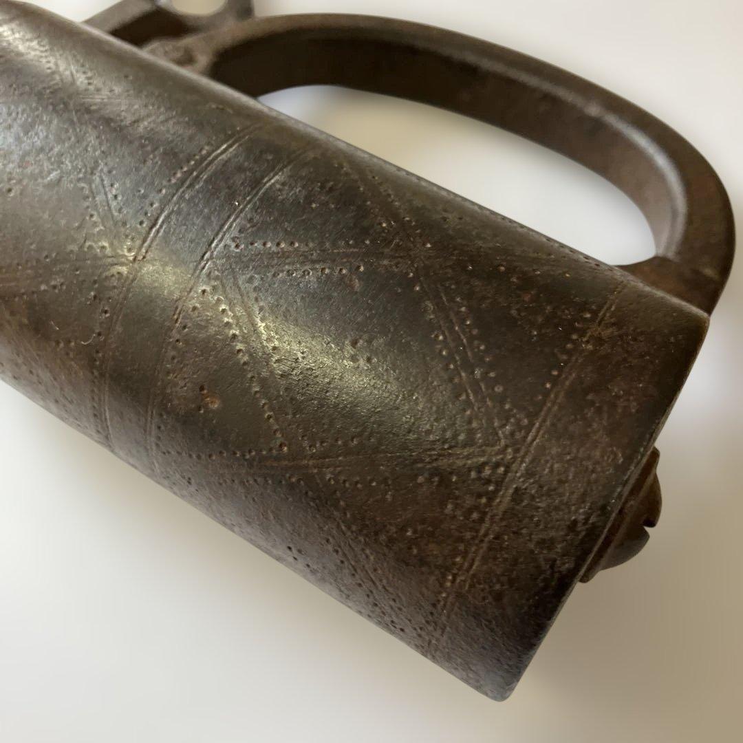 アンティークな鉄製スクリュー式円筒型南京錠（表面には点描幾何学模様）