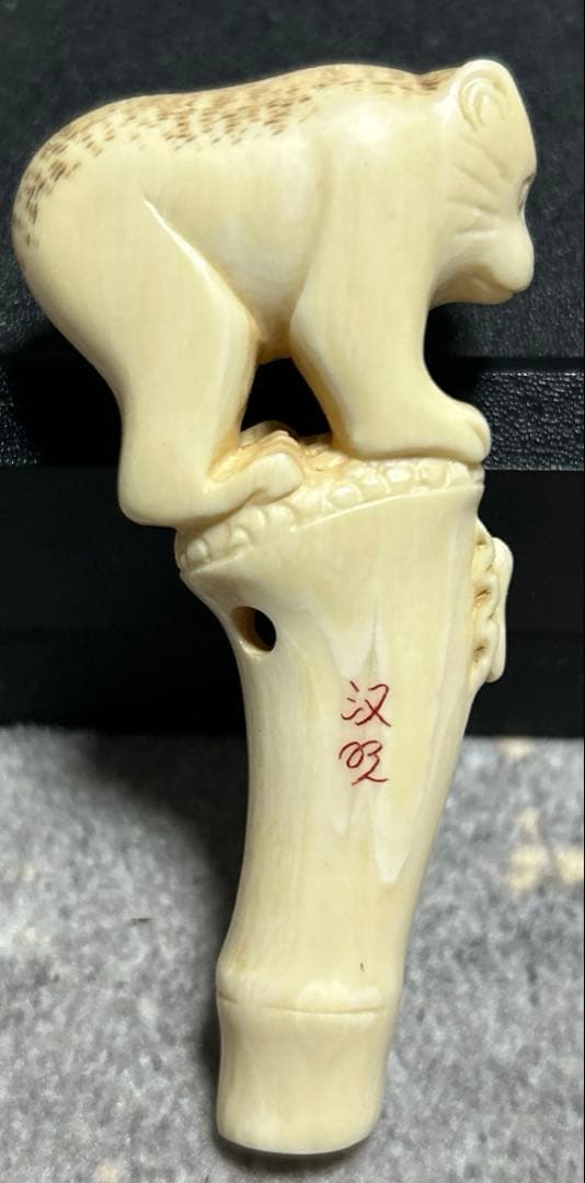 根付 竹の子に止まりバッタを見つめる猿の姿をしている根付