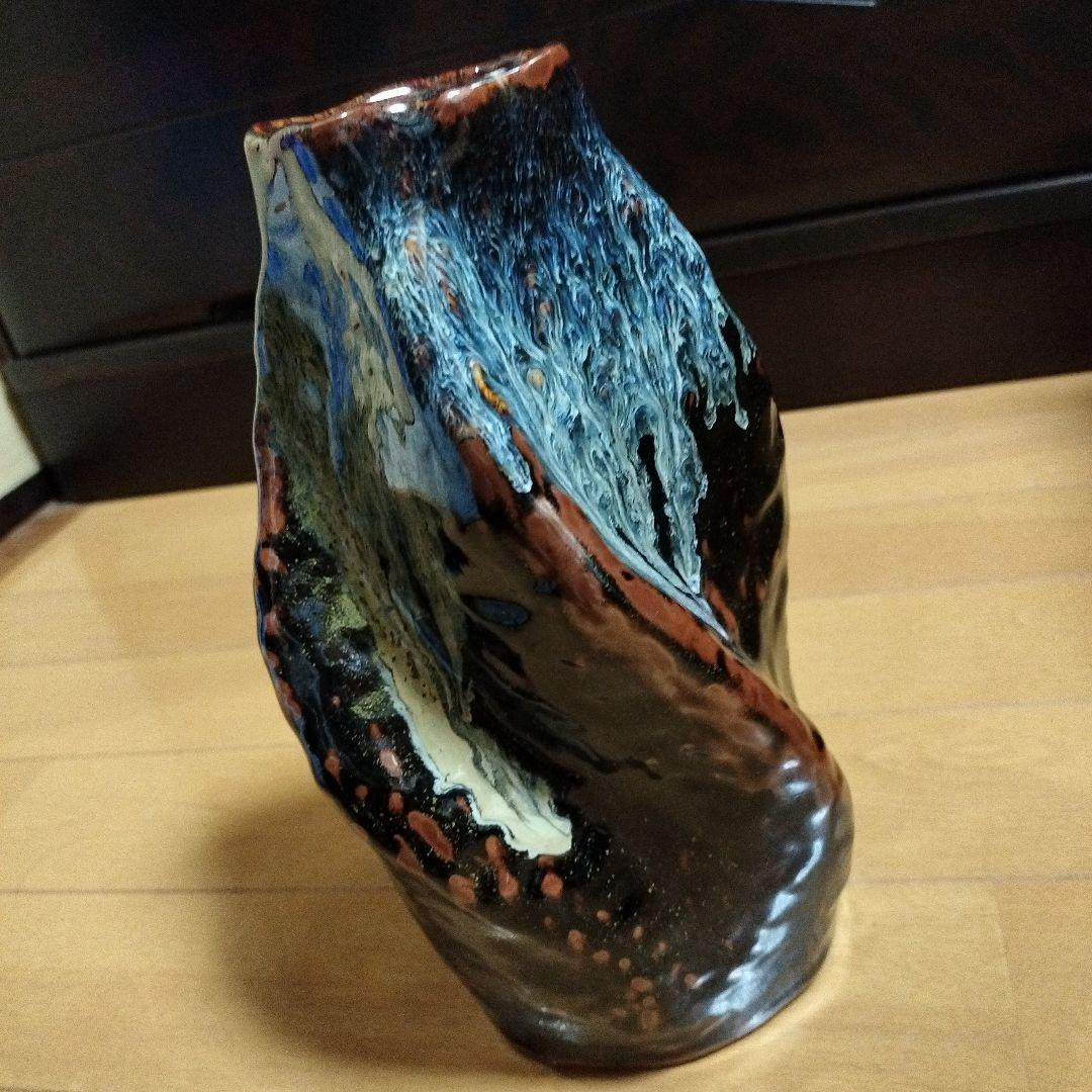 黒色地に青と白と茶の陶器花瓶