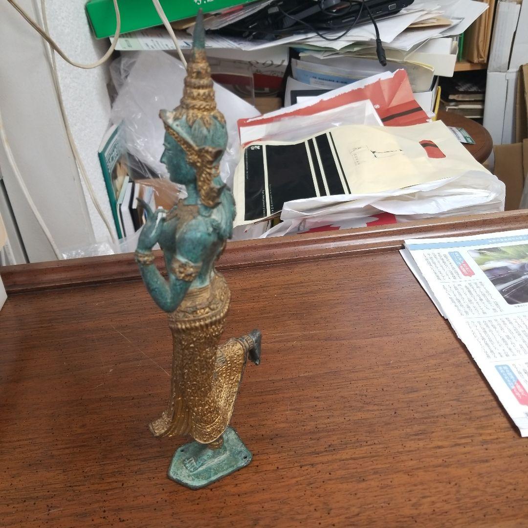 青銅色と金色のアジアの立像