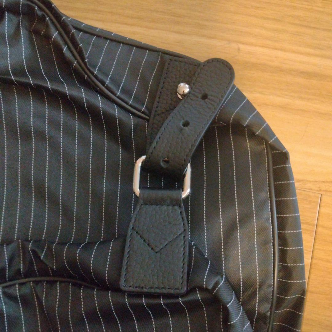 ZEGNA ストライプデザインの黒色ガーメントケース、レザー製ハンドル付き。
