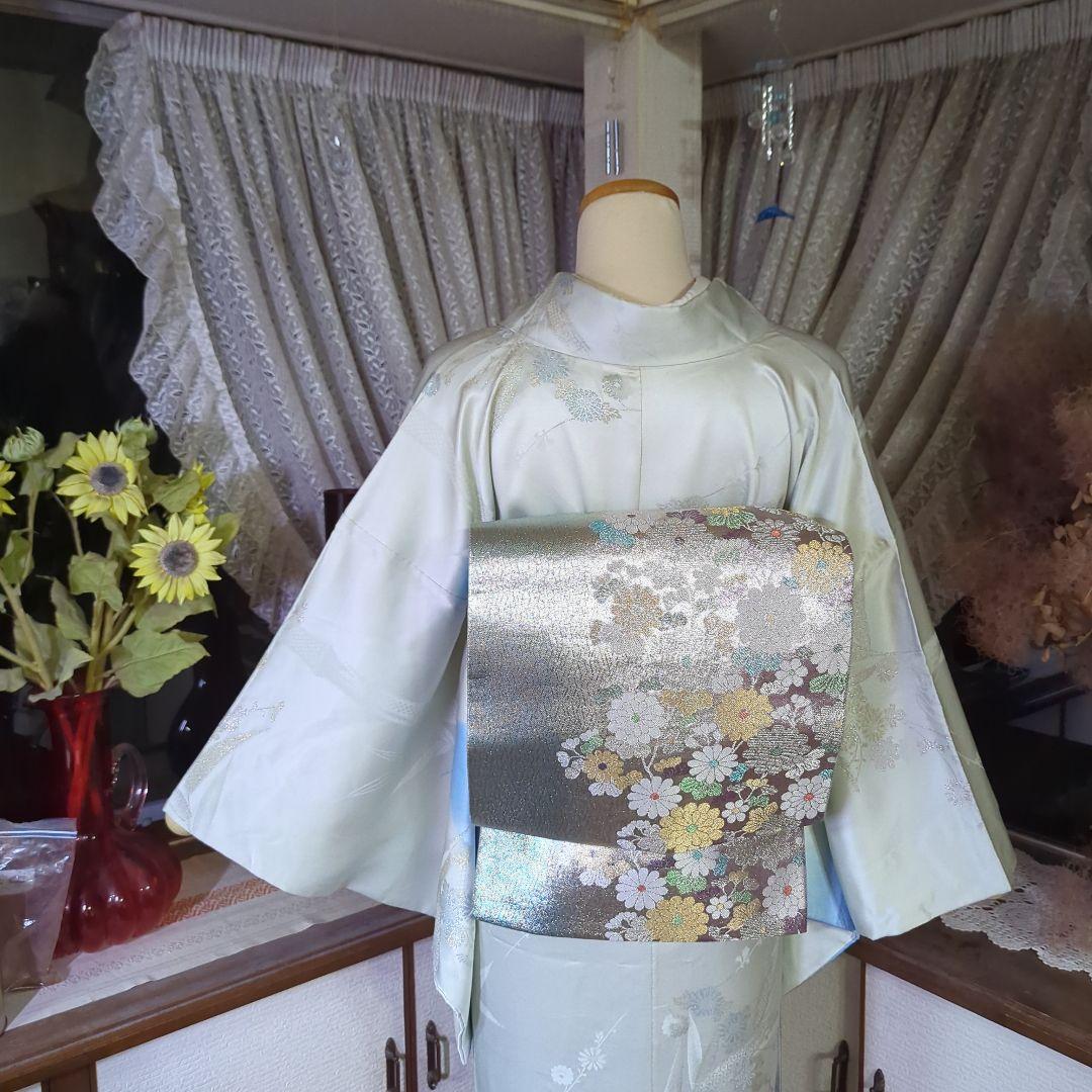 虹色に煌めくシルバーの地に、菊の花が艶やかに咲く、美しい正絹袋帯です