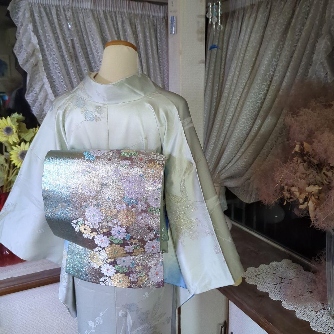 虹色に煌めくシルバーの地に、菊の花が艶やかに咲く、美しい正絹袋帯です