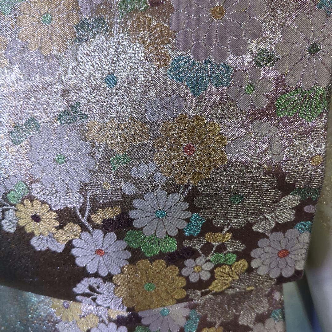虹色に煌めくシルバーの地に、菊の花が艶やかに咲く、美しい正絹袋帯です