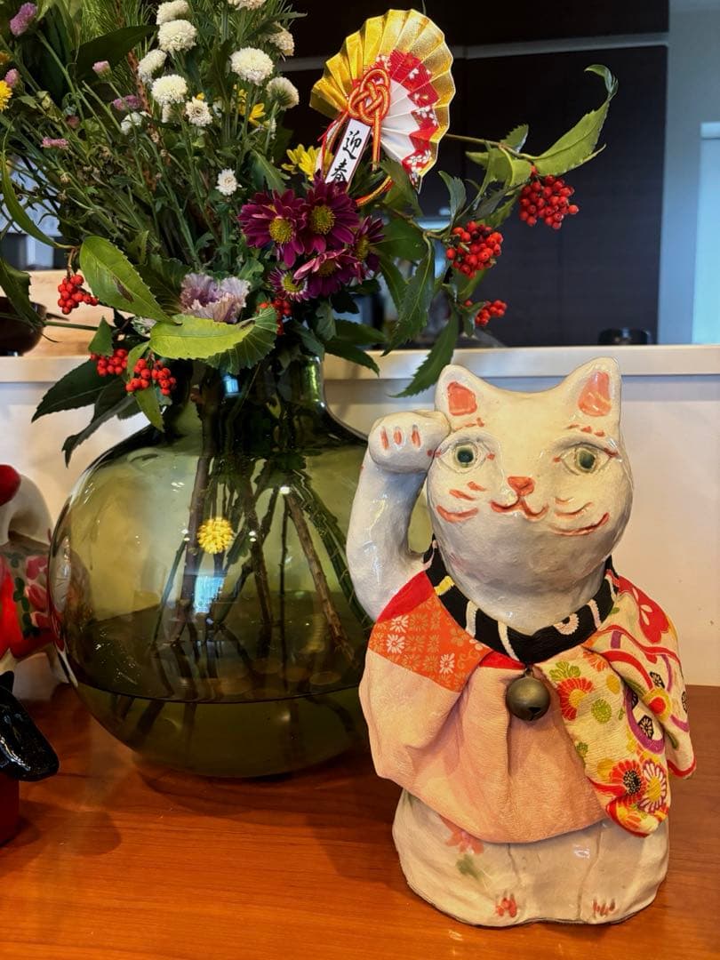 作家さんによる大きな瞳でにっこりと笑う着物の前掛けも美しい招き猫