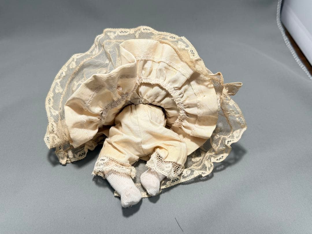 レースドレスをまとったベビーのアンティークドール。陶器製2フェイス