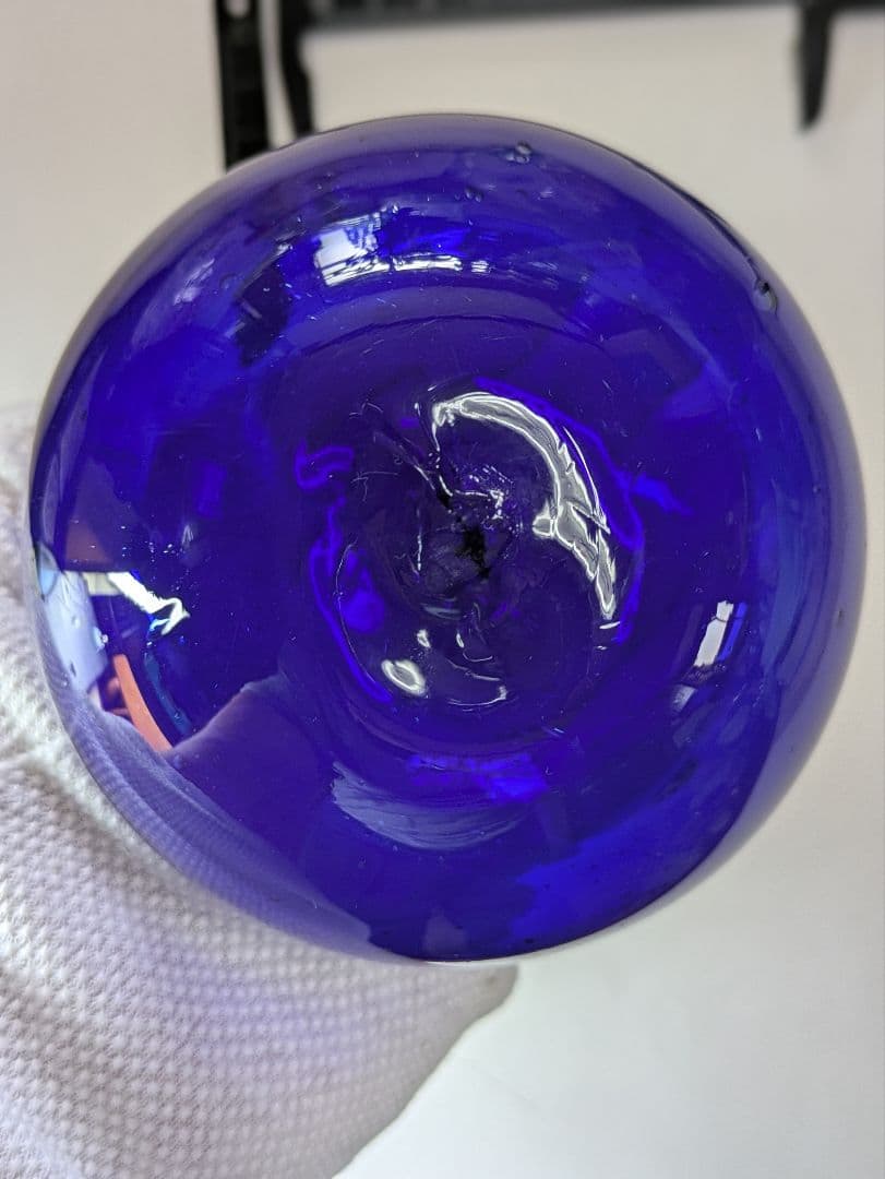 ガラスの浮き玉です。サイズは約90㍉×90㍉です。瑠璃色？少し製造過程の凹凸有り