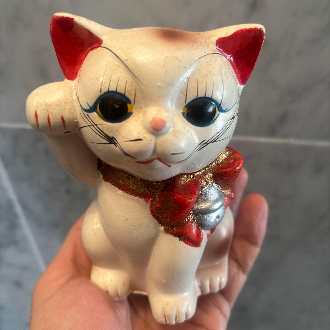 アンティーク大きな瞳や長いヒゲ、まつ毛が美しく、大きなリボンも可愛い招き猫